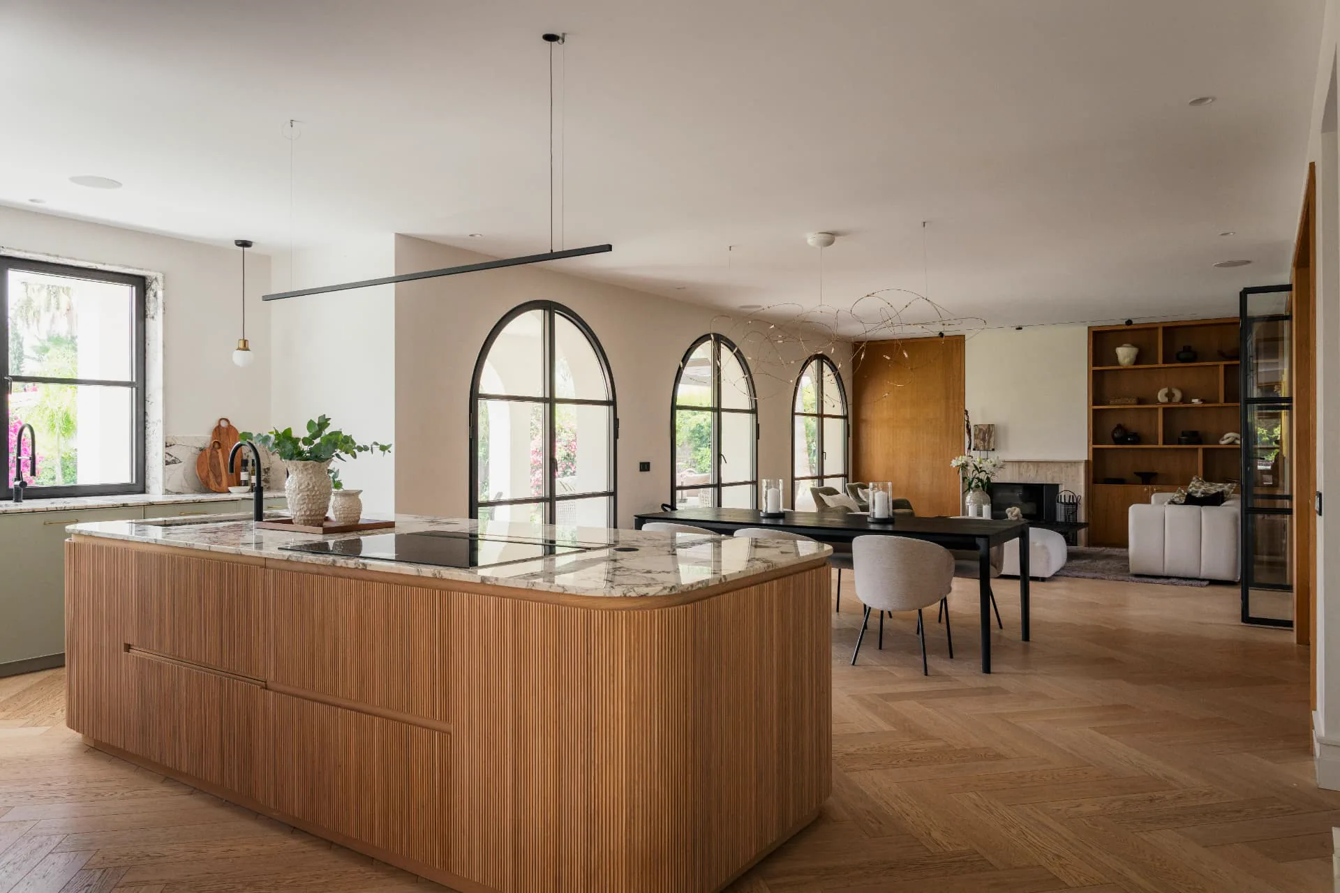 Arched steel-framed doors opening from the kitchen to the terrace
