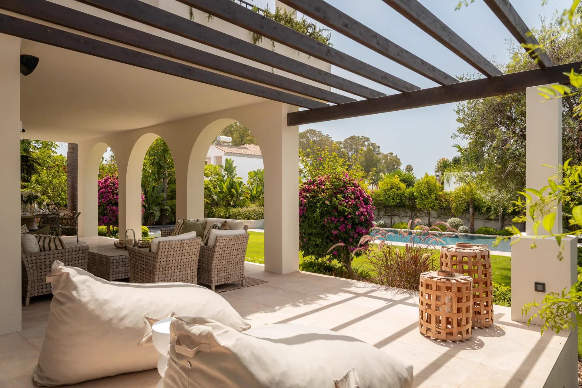 The shaded pergola terrace above the pool, hung with vines and bougainvillea