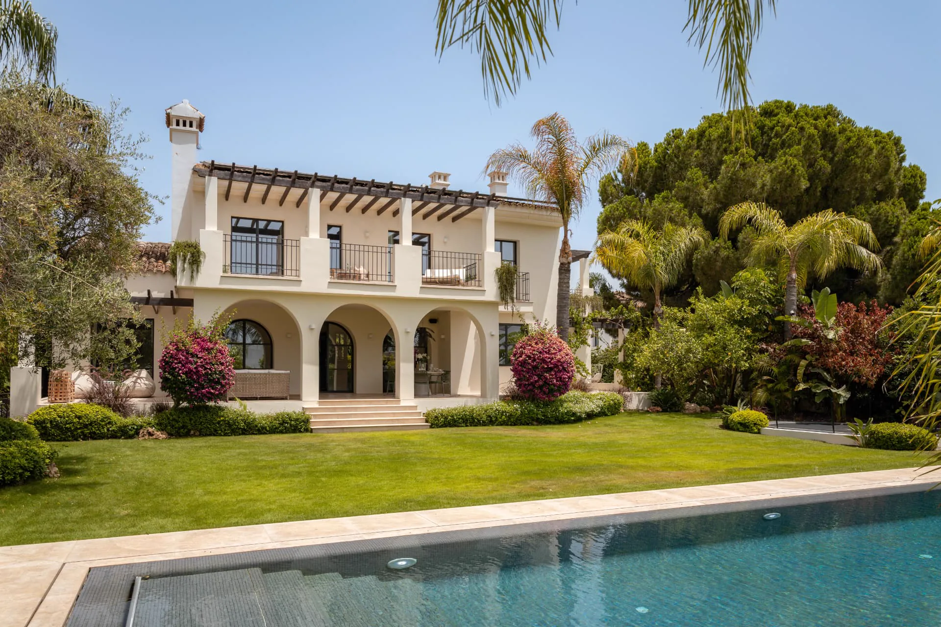 The residence, terraces and full-length pool from the garden's western edge
