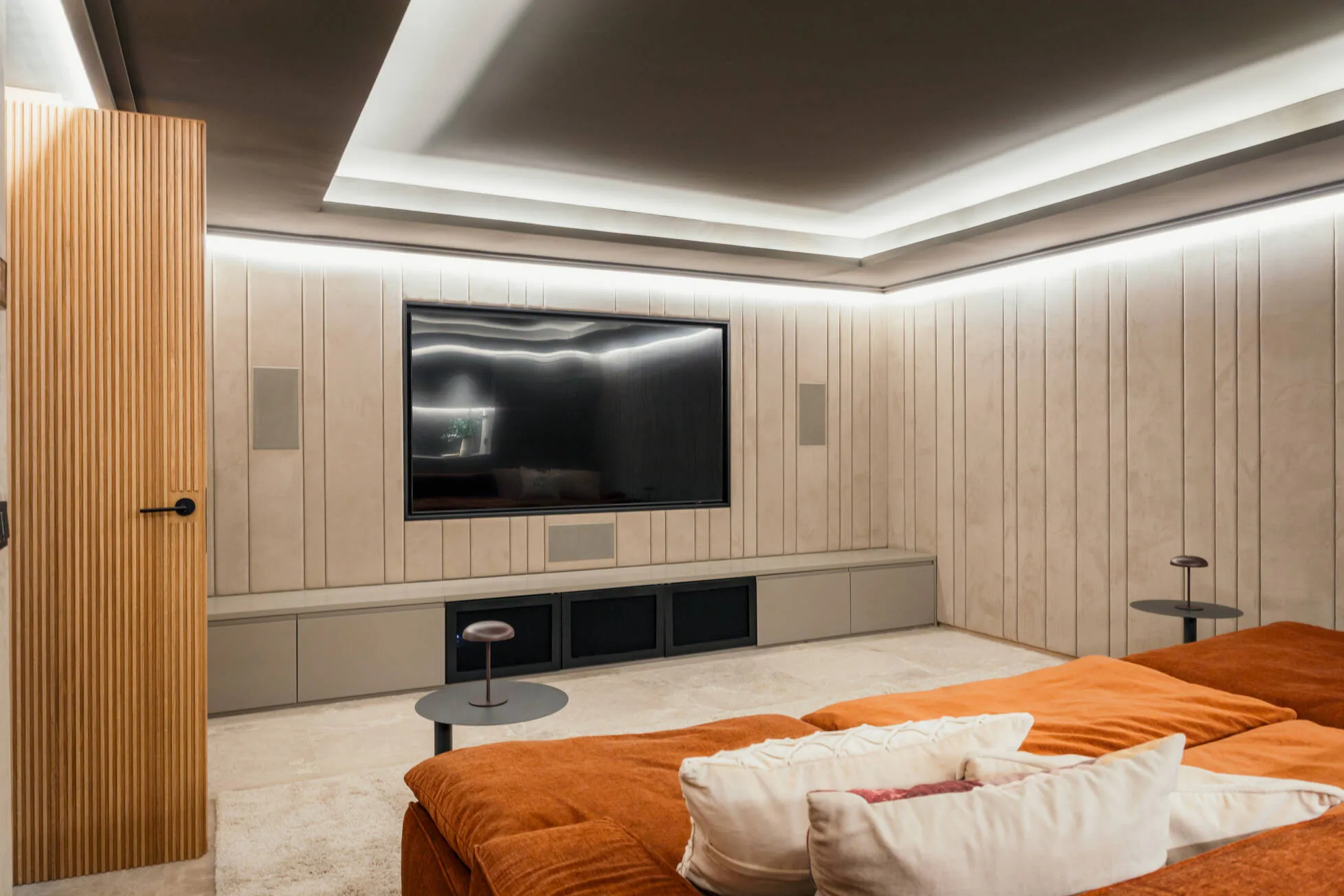 The private cinema with limestone panelling and deep terracotta seating