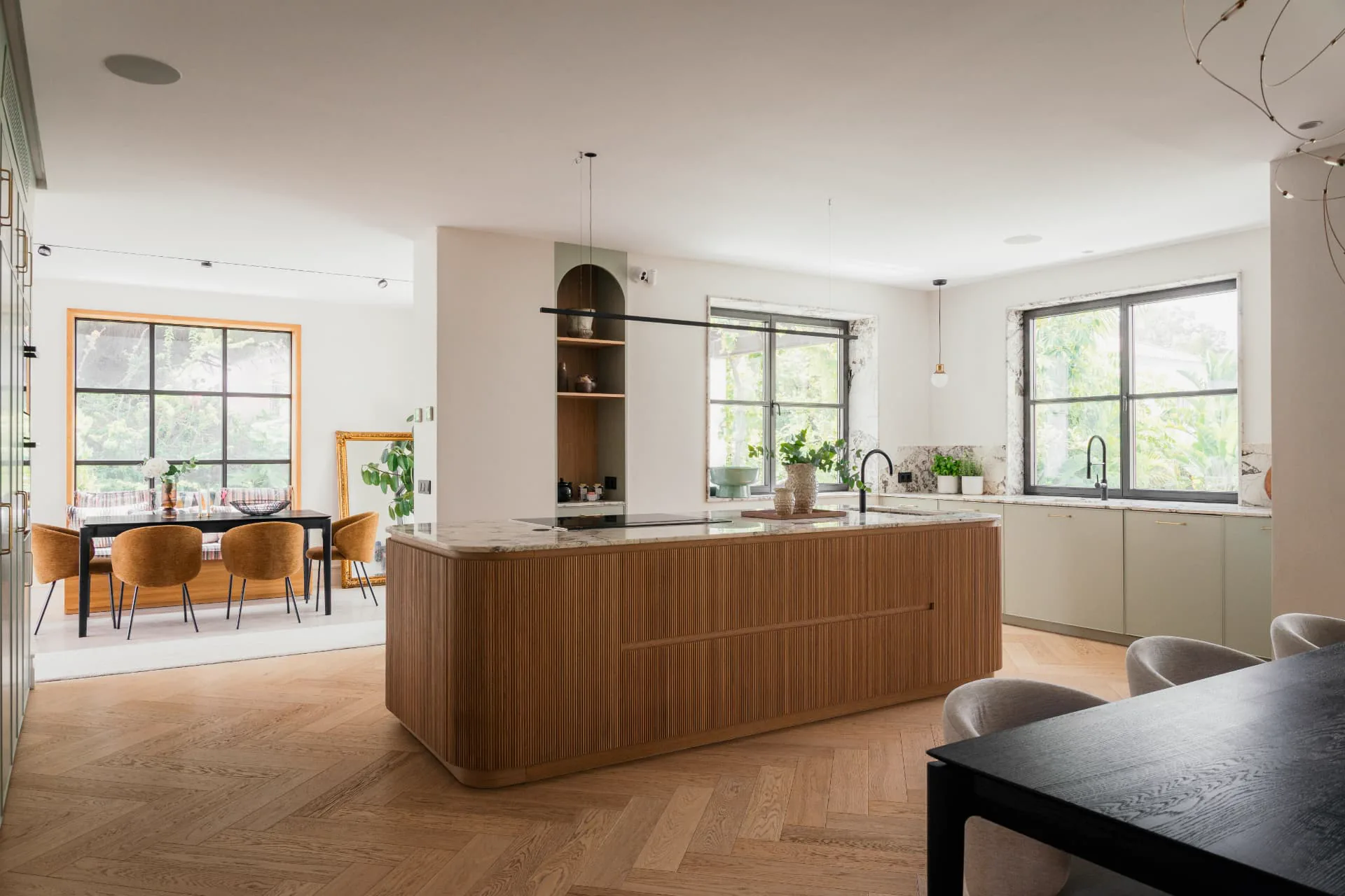 The kitchen island in fluted oak, topped with veined marble