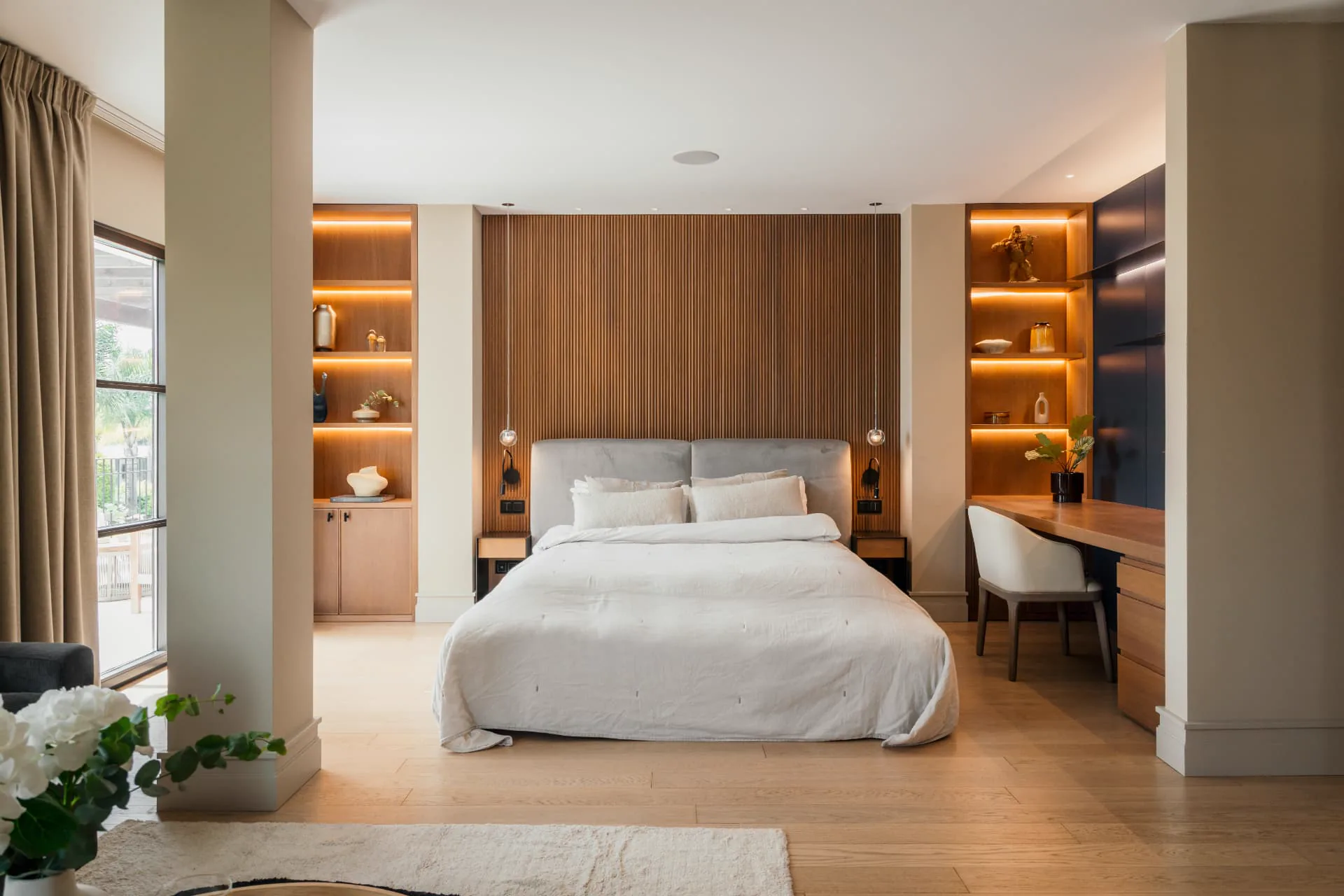 The principal bedroom with fluted walnut headboard wall and lit joinery