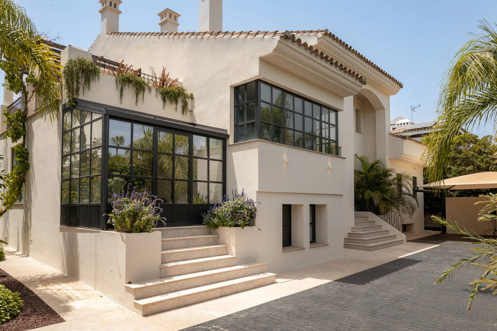 The steel-framed orangery and entrance steps, lavender in stone planters