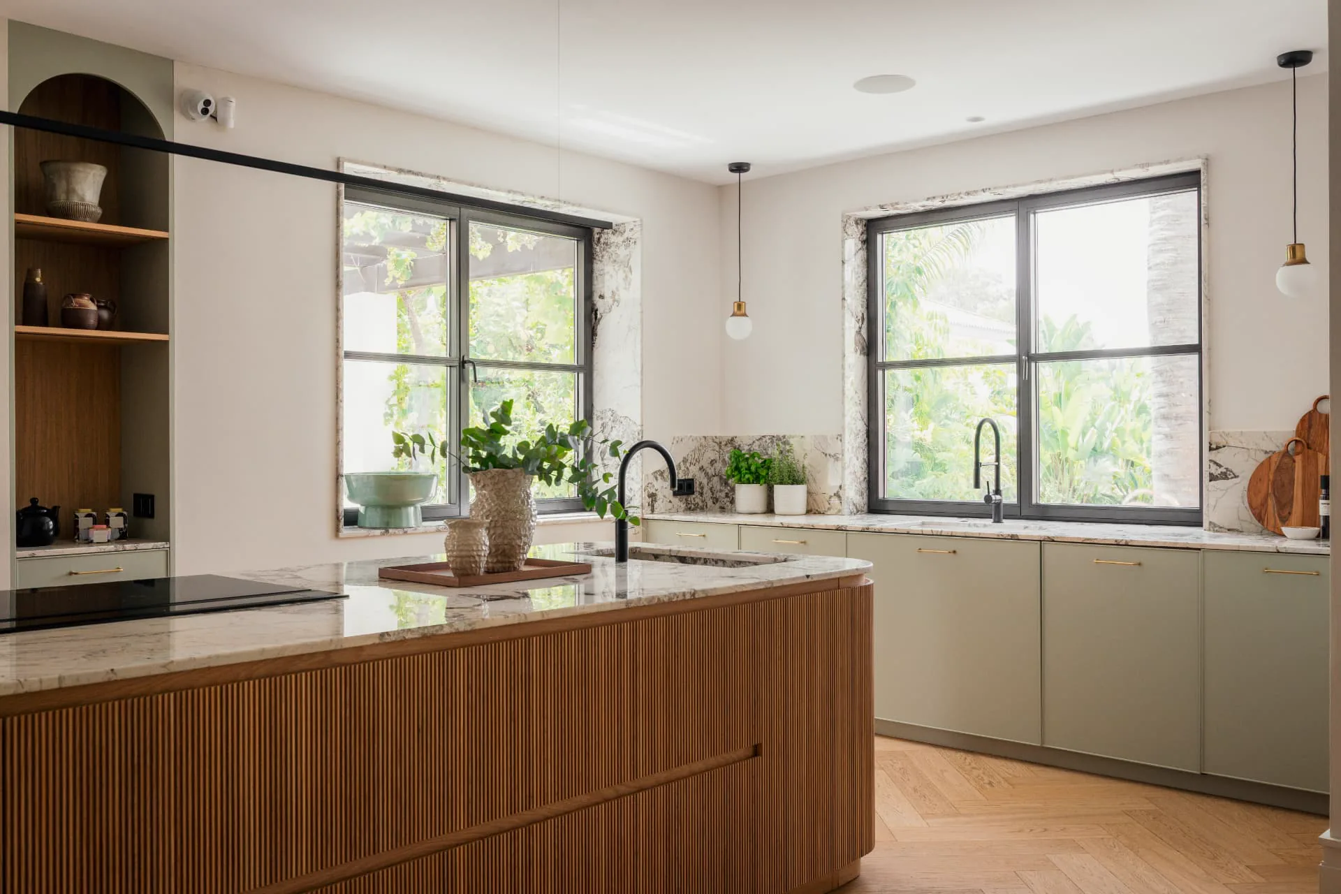Marble-framed windows above the olive-green kitchen run